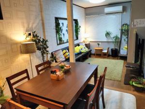 ein Wohnzimmer mit einem Tisch und einem Sofa in der Unterkunft Peaceful inn breeze - Vacation STAY 16612 in Osaka