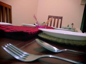 een tafel met een vork en kommen op een tafel bij Kili House Hostel in Arusha