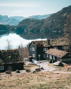 um grupo de casas com um lago ao fundo em Preikestolen BaseCamp em Jørpeland