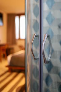a glass door with two handles in a bedroom at Hotel Boutique Casa de Arte Oaxaca, Art Gallery & Pool in Oaxaca City