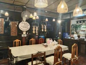 a dining room with a table and chairs and lights at PunNa Homestay @ Bangsai in Ban Bang Sai