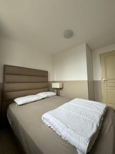 una camera da letto con un grande letto con lenzuola bianche di Beau 2 pièces, au pied des pistes Résidence Adonis a Valberg