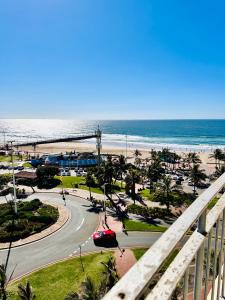 uitzicht op het strand vanaf het balkon van een resort bij Nomacurvy beach front accommodation in Durban