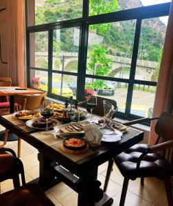 una mesa con platos de comida en ella con una ventana en Hotel Gorica - UNESCO quarter, en Berat