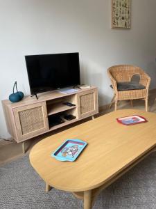 a living room with a tv and a coffee table at Appartement Le Fayot in Wimereux