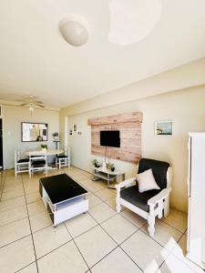 a living room with a couch and a tv at Nomacurvy beach front accommodation in Durban
