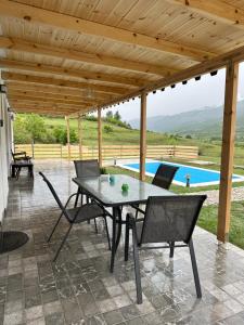 a patio with a table and chairs and a pool at Villa Xheni in Fshati i Ri