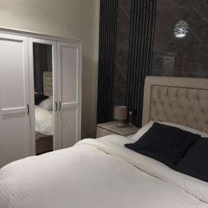 um quarto com uma grande cama branca e um espelho em Elegance em Firq