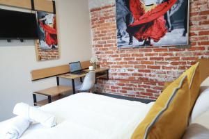 una camera da letto con un muro di mattoni, un letto e una scrivania di Casa Pánuco a Città del Messico