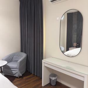 a bedroom with a mirror and a chair and a bed at The Elegance Rooms in Firq