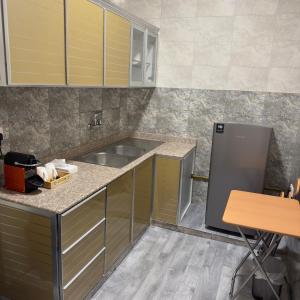 a kitchen with a sink and a refrigerator at Elegance in Firq