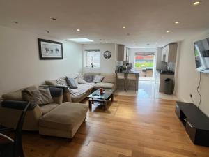a living room with a couch and a table at Southgate 5 bedroom property in East Barnet