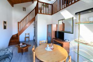 un salon avec une table en bois et une télévision dans l'établissement Logis Hotel & Restaurant Bergeret Sport, à Hendaye