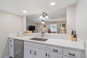 a kitchen with white cabinets and a sink at Gulf View 16 by Vacation Homes Collection in Gulf Shores