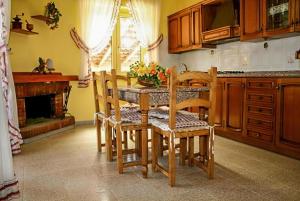 una cucina con tavolo, sedie e camino di Villa Fiorita a Casal Velino