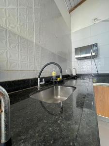 - un comptoir de cuisine avec évier dans la chambre dans l'établissement Casa Amarela - Raiô Baixú Hospedagem, à Caraíva