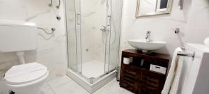 uma casa de banho com um chuveiro, um WC e um lavatório. em Studio Apartmani “Jarnečić” em Krk