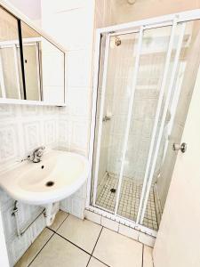 a bathroom with a sink and a shower at Nomacurvy beach front accommodation in Durban
