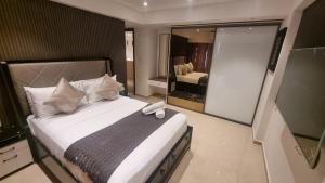 a bedroom with a large bed with a large mirror at Solaris Apartments luxury by Cozy in Accra +40 photos