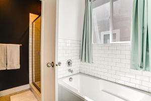 a white bathroom with a tub and a window at Vineyard Retreat with Gas Grill Near Utah Lake! in Vineyard +21 photos