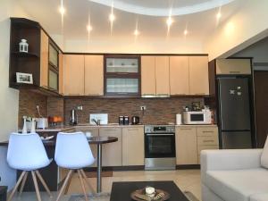 a kitchen with a couch and a table in a room at Sofia's modern apartment in Gjirokastër