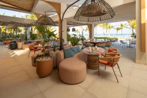 ein Restaurant mit Tischen und Stühlen und Meerblick in der Unterkunft The Westin Puntacana Resort in Punta Cana