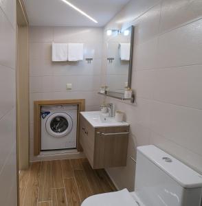 a bathroom with a washing machine and a washer at DUOMO City Center Suites in Heraklio Town