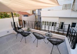 a balcony with four chairs and a table at DUOMO City Center Suites in Heraklio Town