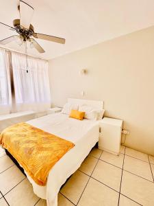 a bedroom with a bed and a ceiling fan at Nomacurvy beach front accommodation in Durban