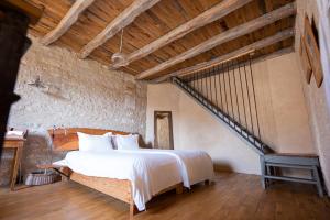 um quarto com uma cama grande e uma escada em Domaine De Chantemerle B'nB em Marsac