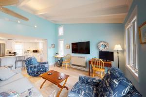 uma sala de estar com um sofá e uma mesa em Sea and Be em West Yarmouth