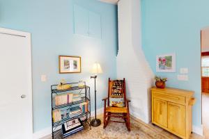 um quarto com uma estante de livros, um candeeiro e uma cadeira em Sea and Be em West Yarmouth