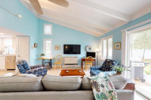 uma sala de estar com paredes azuis e um sofá e cadeiras em Sea and Be em West Yarmouth