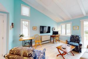 a living room with a couch and a table at Sea and Be in West Yarmouth
