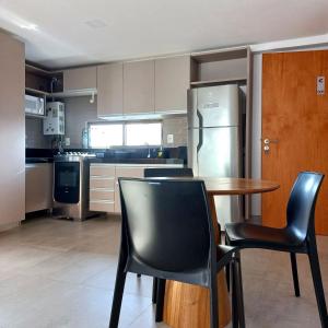 La cuisine est équipée d'une table, de chaises et d'un réfrigérateur. dans l'établissement Freitas Residence - Quinta Manuel Rodrigues, à Récife