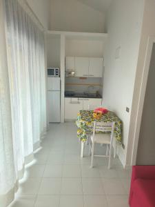una cocina con mesa y una cocina con mesa y sillas en Sul Mare con Posto Auto e Terrazzo, en Marcelli