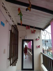 a woman walking through a doorway with butterflies hanging from the ceiling at Morada Ítaca - Arboletes in Arboletes