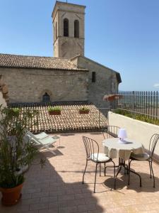 een patio met stoelen en een tafel en een gebouw bij App. con terrazza panoramica in centro-Montefalco in Montefalco