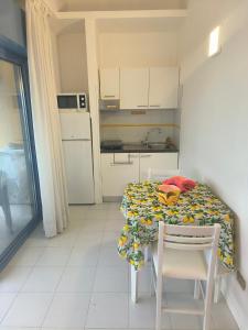 une petite cuisine avec une table, une table et des chaises dans l'établissement Sul Mare con Posto Auto e Terrazzo, à Marcelli