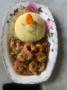 ein Teller Garnelen und Reis auf dem Tisch in der Unterkunft Sita Joyeh Baobab Island Hotel in Kuloro