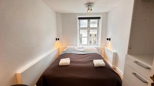 a small room with a bed with two towels on it at Central apartment - RAP 7 in Copenhagen