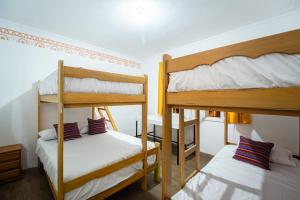 2 łóżka piętrowe w małym pokoju z łóżkiem w obiekcie Casa Águila y Cóndor w mieście Lima