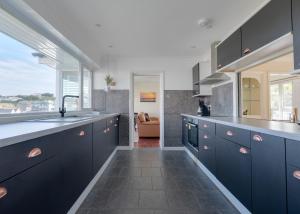 a kitchen with blue cabinets and a sink at Beach Haven in Wadebridge