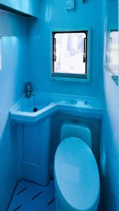 a blue bathroom with a toilet and a sink at Casa Rodante amplia en Cusco in Cusco