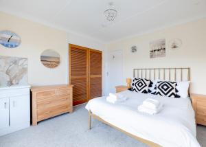 ein Schlafzimmer mit einem großen Bett und einer Kommode in der Unterkunft Beach Haven in Wadebridge