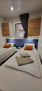 1 dormitorio con 2 camas y ventana en Mobile home JOY, en Biograd na Moru