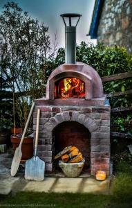 un horno de ladrillo con un fuego dentro de él en Family House with Garden & Sea Views, en Mousehole