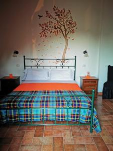 - une chambre avec un lit et un arbre sur le mur dans l'établissement Meriggio, à Catabbio