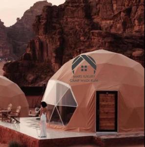 a woman standing in front of two tents at MARS lUXURY CAMP WADI RUM in Wadi Rum