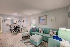 a living room with a green couch and a kitchen at Gulf Tower 3C by Vacation Homes Collection in Gulf Shores